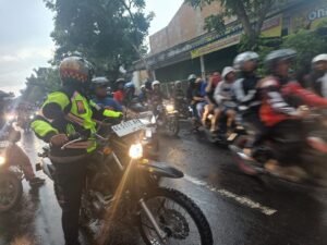 Di Bawah Guyuran Hujan Lebat, Kabag Ops Polres Kediri Kota Lakukan Pengamanan dan pengawalan Perjalanan Pulang Massa Pesilat